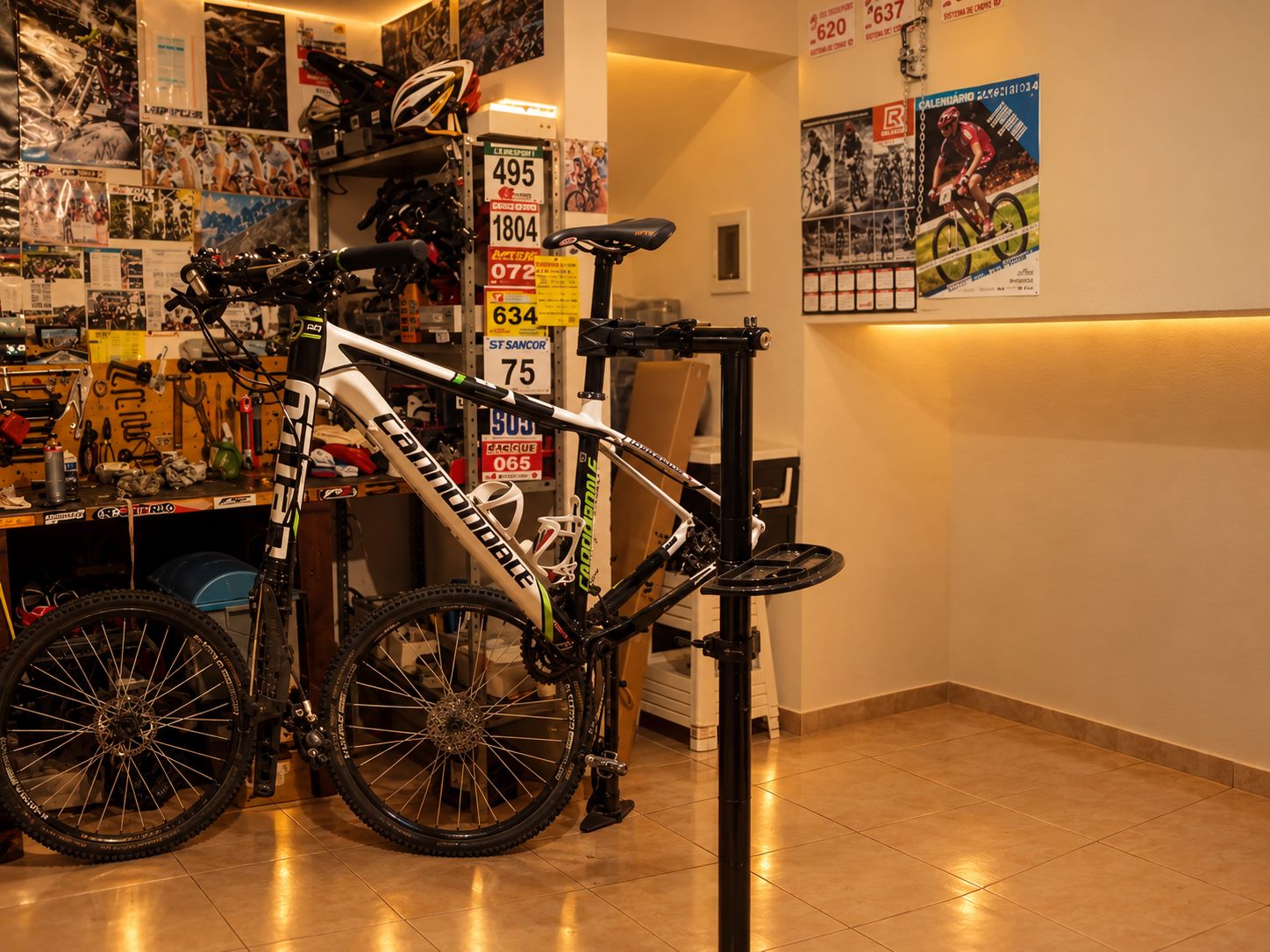 A primeira oficina da Merlo Bike Garage, na garagem, com bike no cavalete e a bancada de ferramentas